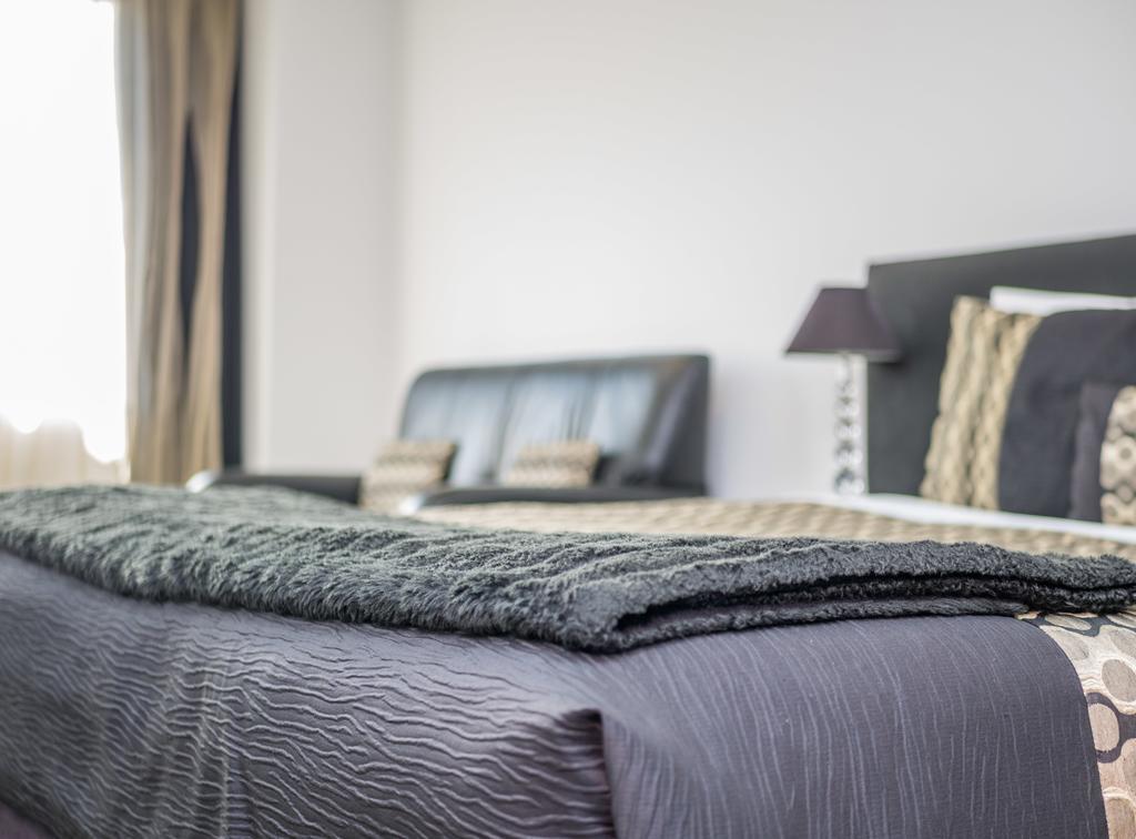 Bellano Motel Suites Christchurch Eksteriør billede A bed with a throw