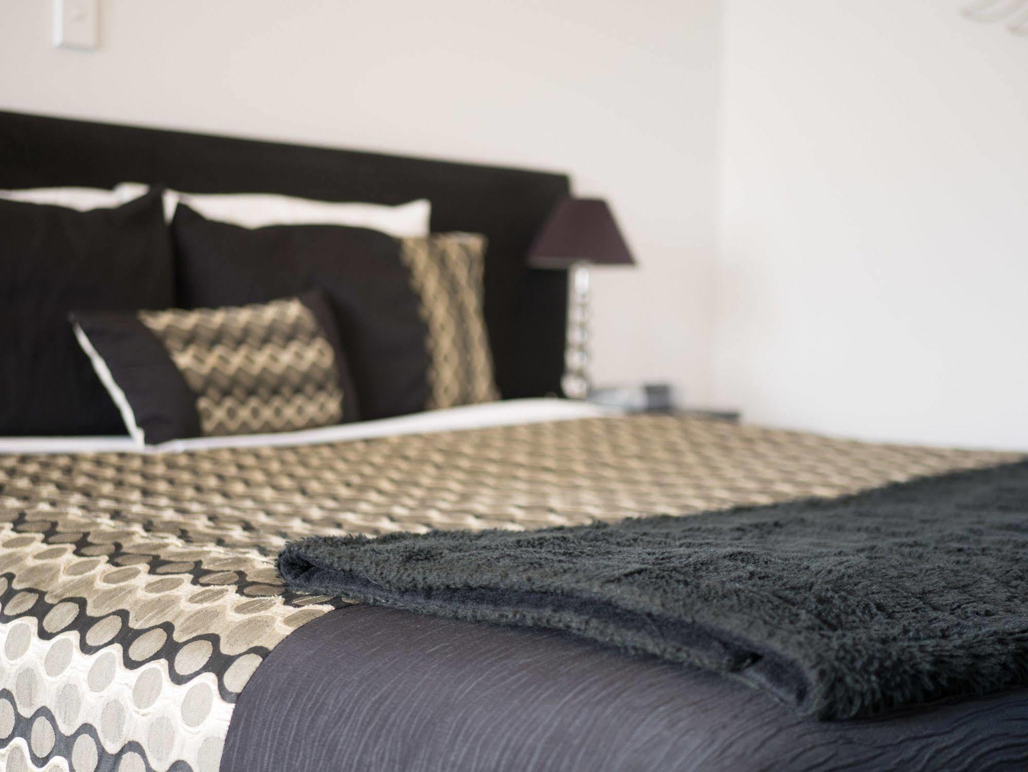 Bellano Motel Suites Christchurch Eksteriør billede A bed with a throw